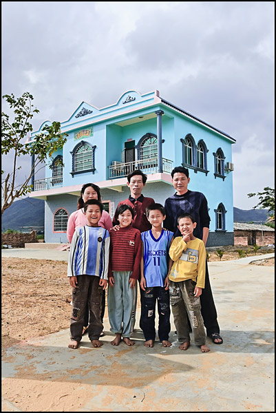 Family posing in front of their house