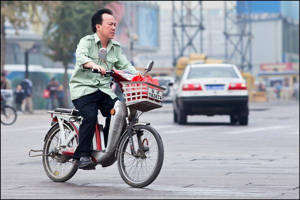 Man op e-bike op kruispunt 