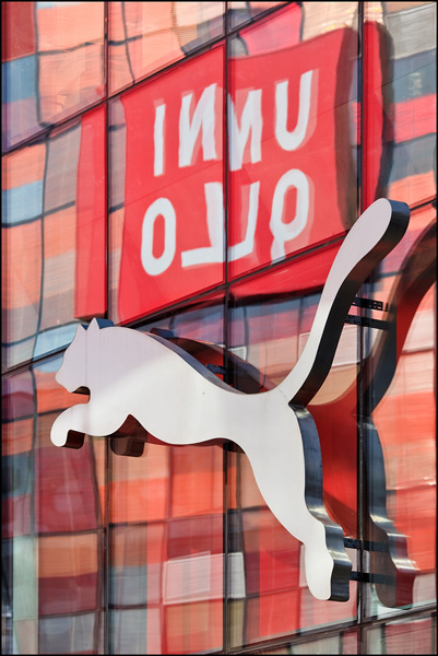 Uniqlo logo reflected in glass surface Puma store