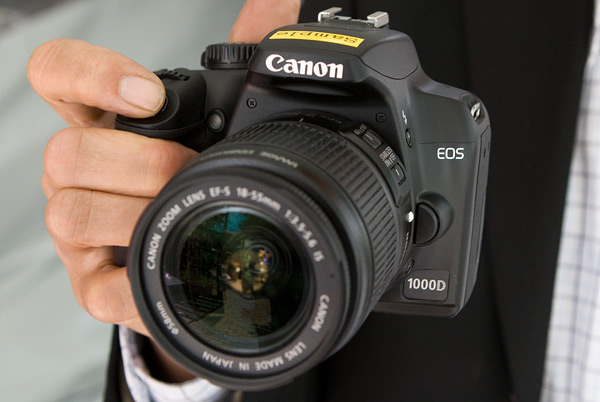 De Canon 1000D in de hand De Canon 1000D in de hand