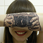 Fotografe Lotte laat camera op haar arm tatoeëren