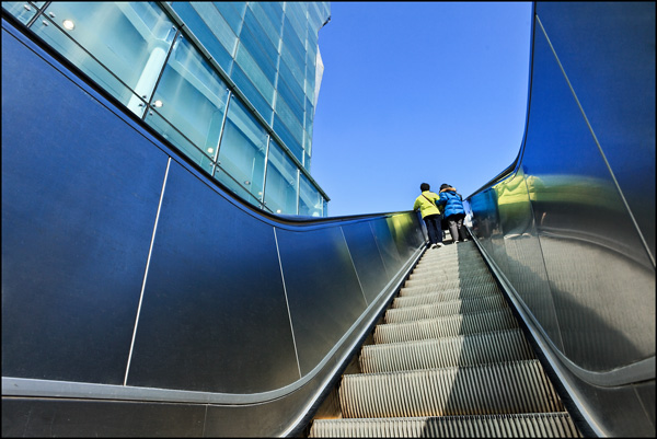 Two people on an escalator