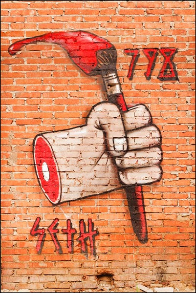 Graffiti van hand met verfkwast op rode bakstenen muur Graffiti van hand met verfkwast op rode bakstenen muur
