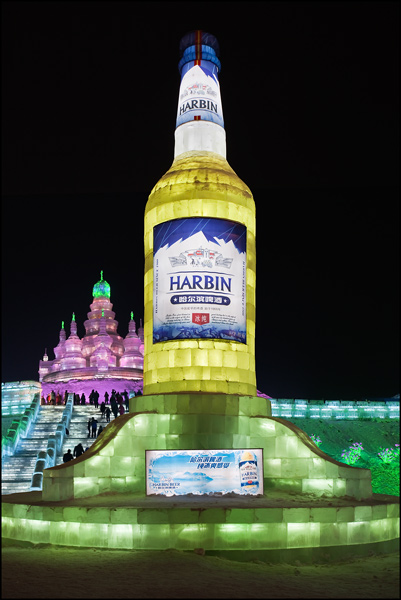 Tall ice sculpture of a yellow beer bottle=