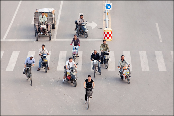 fietsers en scooters op een kruispunt in de vroege ochtend