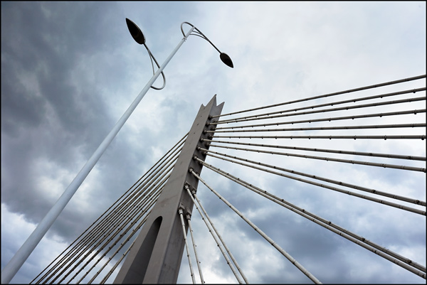 Spankabels van een brug met dreigende wolkenpartij