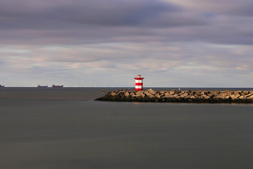 Het vuurtorentje op het noordelijke havenhoofd van Scheveningen. Merk op hoe zijdezacht zee en wolken aandoen. Sluitertijd 60 sec bij ISO 400 en f/11.